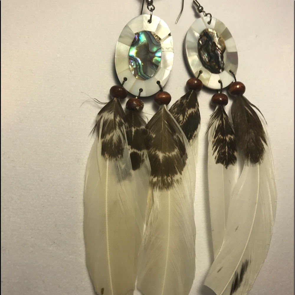 Oval earrings with white feathers.